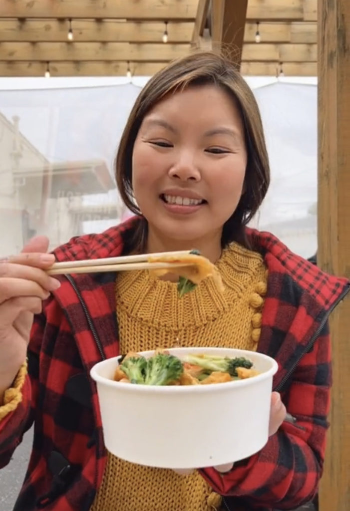 Woman (Linda) holding up bowl of Thai noodles